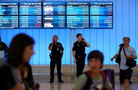 FILE PHOTO: U.S. Customs and Immigration officers keep watch at the arrivals level at Los Angeles International Airport in Los Angeles, California, U.S., June 29, 2017. REUTERS/Mike Blake