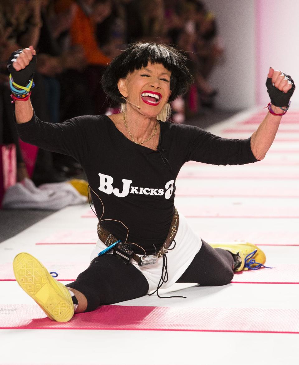 Designer Betsey Johnson greets the audience with her trademark cartwheel and split following a showing of her Fall 2013 collection during Fashion Week in New York, Monday, Feb. 11, 2013. (AP Photo/John Minchillo)