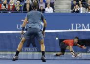 Novak Djokovic of Serbia reaches down to hit a return to Rafael Nadal (L) of Spain during their men's final match at the U.S. Open tennis championships in New York, September 9, 2013. REUTERS/Ray Stubblebine (UNITED STATES - Tags: SPORT TENNIS)