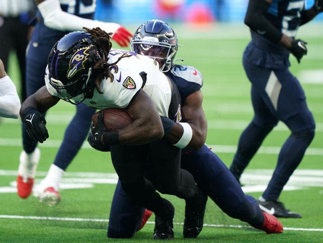 Baltimore Ravens' Gus Edwards is tackled by Tennessee Titans' Azeez Al-Shaair