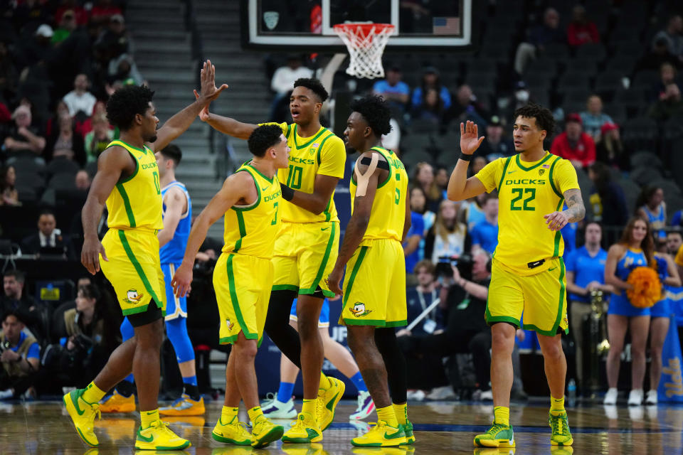 Oregon Ducks guard Kario Oquendo (0), guard Jackson Shelstad (3), forward Kwame Evans Jr. (10), guard Jermaine Couisnard (5) and guard Jadrian Tracey (22) celebrate in the second half against the UCLA Bruins at T-Mobile Arena March 14, 2024, in Las Vegas.