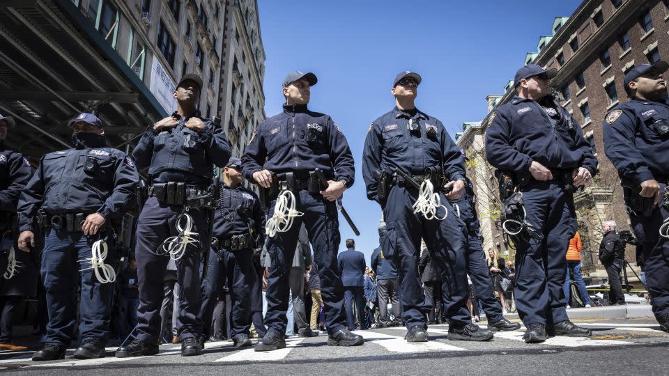 NYPD officers from the Strategic Response Group form a wall of protection around Deputy Commissioner of Legal Matters Michael Gerber and Deputy Commissioner of Operations Kay Daughtry, not pictured, during a news conference regarding the protest encampment at Columbia University on April 22, 2024. - Stefan Jeremiah/AP