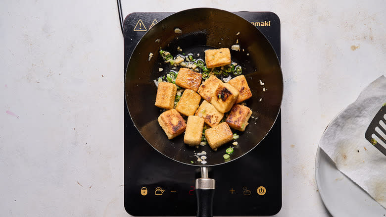 frying tofu in wok