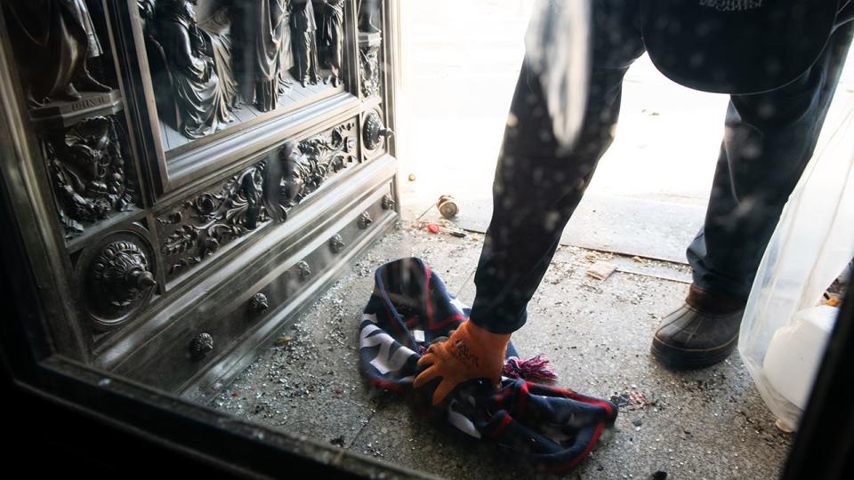 A worker removes a Trump scarf from the East Front of the U.S. Capitol building in Washington, D.C., U.S., on Thursday, Jan. 7, 2021. Joe Biden was formally recognized by Congress as the next U.S. president early Thursday, ending two months of failed challenges by his predecessor, Donald Trump, that exploded into violence at the U.S. Capitol as lawmakers met to ratify the election result.