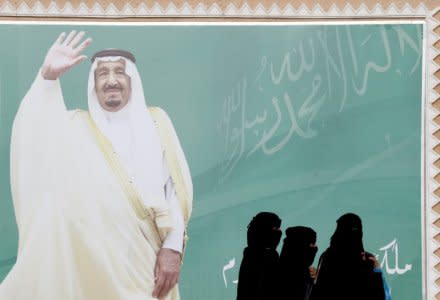 FILE PHOTO: Women walk past a poster of Saudi Arabia's King Salman bin Abdulaziz Al Saud during Janadriyah Cultural Festival on the outskirts of Riyadh, Saudi Arabia February 12, 2018. REUTERS/Faisal Al Nasser/File Photo