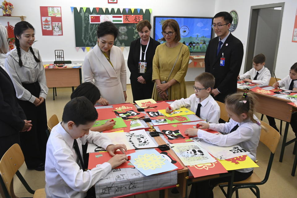 Peng Liyuan, center left, wife of Chinese President Xi Jinping watches the activity of third graders as she, and Aniko Levai, center right, wife of Hungarian Prime Minister Viktor Orban visit a classroom at the Chinese-Hungarian bilingual school of Budapest, Hungary, Thursday May 9, 2024 during the state visit of President Xi to Hungary. (Zoltan Mathe/MTI via AP)