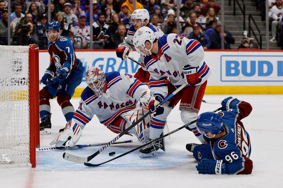 Mar 28, 2024; Denver, Colorado, USA; New York Rangers goaltender Igor Shesterkin (31) looks to cover up the puck against Colorado Avalanche right wing Mikko Rantanen (96) as defenseman Adam Fox (23) defends in the second period at Ball Arena.