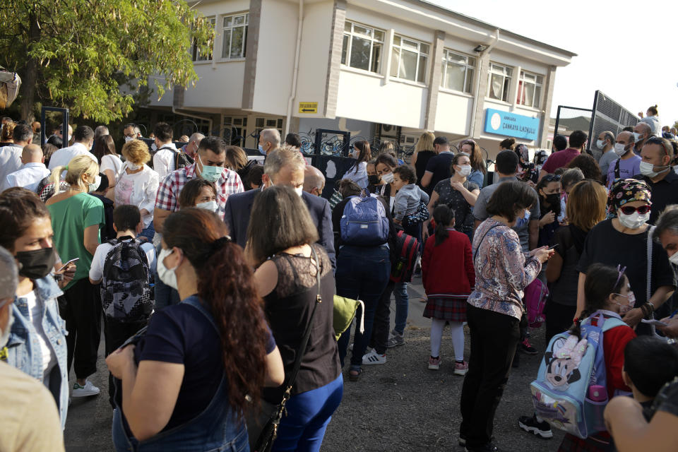 Pupils and parents arrive back at Cankaya Primary School in Turkish capital Ankara as schools reopen after 18 months' closure due to COVID-19, Monday, Sept. 6, 2021. The Turkish government has decided to reopen schools and colleges in the country of 84 million - one of the world's youngest with 18 million students.(AP Photo/Burhan Ozbilici)