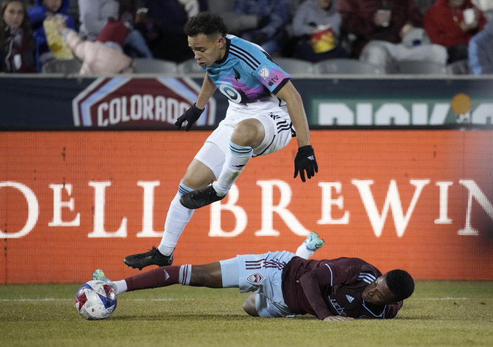 Minnesota United midfielder Hassani Dotson jumps over Colorado Rapids midfielder Max in pursuit of the ball during the second half of an MLS soccer match Saturday, March 18, 2023, in Commerce City, Colo. (AP Photo/David Zalubowski)