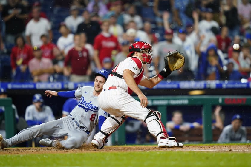Dodgers' Trea Turner, left, slides past Phillies catcher J.T. Realmuto during the sixth inning Aug. 10 in Philadelphia.