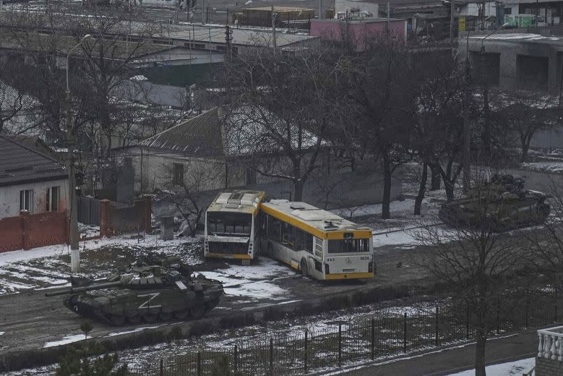 Russian army tanks move down a street on the outskirts of Mariupol, Ukraine, March 11, 2022.