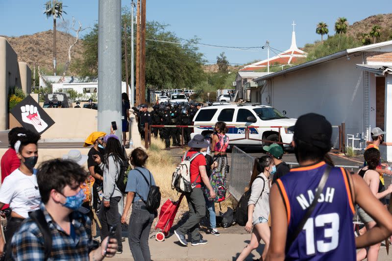 Police file down an ally towards protestors during the visit by U.S. President Donald Trump to the Dream City Church in Phoenix