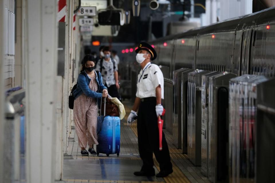 A railway station attendant in Tokyo - getty