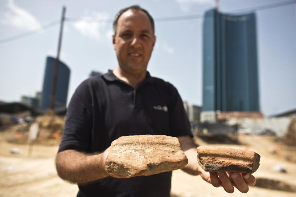 Diego Barkan, director of the excavation for the Israel Antiquities Authority (IAA), shows fragments of ancient basins unearthed at an archaeological dig in a future construction site in Tel Aviv March 29, 2015. Fragments of ancient beer-brewing basins unearthed in Tel Aviv indicate that Egyptians more than 5,000 years ago had settled farther north than previously known and were imbibing in what is now Israel's most hard-partying city. To match story ISRAEL-EGYPT/BEER REUTERS/Nir Elias