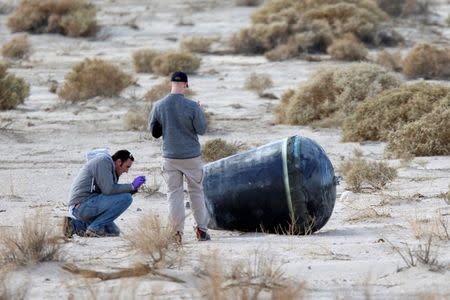 Investigators from the National Transportation Safety Board (NTSB) and Scale Composites inspect wreckage from the crash of Virgin Galactic's SpaceShipTwo near Cantil, California November 1, 2014. REUTERS/David McNew