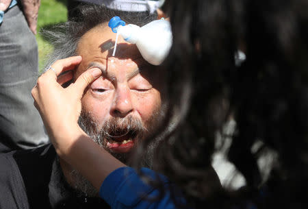 A man is treated after being pepper sprayed during the Patriots Day Free Speech Rally in Berkeley, California, U.S. April 15, 2017. REUTERS/Jim Urquhart