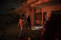 In this April 2, 2019 photo, an Iraqi army 20th division soldier walks with a civilian during a nighttime raid near Badoush, Iraq. The small town on the banks of the Tigris River was once one of the Islamic State group's most diehard strongholds. (AP Photo/Felipe Dana)