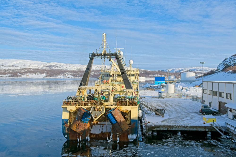 A fishing trawler next to a jetty