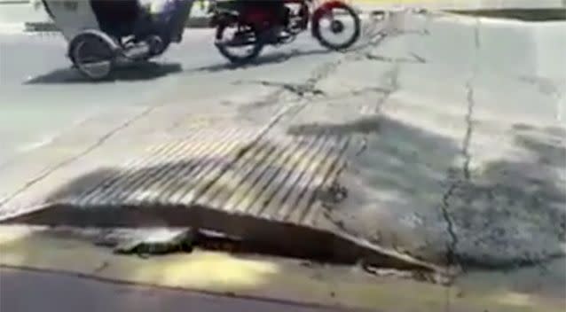 A motorbike and carriage drives over the cracked road. Source: YouTube