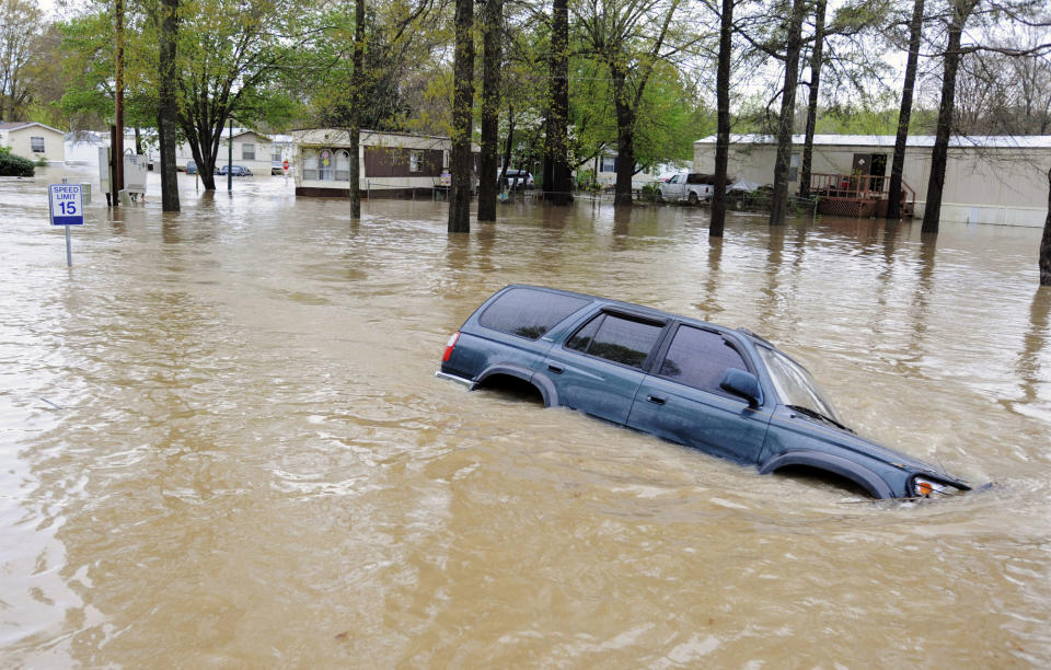 An abandoned vehicle sits submerged by floodwaters on a road in a mobile home park in Pelham, Ala., on Monday, April 6, 2014. Storms dumped torrential rains in central Alabama overnight, causing flooding across the region. (AP Photo/Jay Reeves)