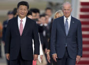 FILE - In this Sept. 24, 2015 file photo, Chinese President Xi Jinping and Vice President Joe Biden walk down the red carpet on the tarmac during an arrival ceremony in Andrews Air Force Base, Md. Chinese leaders hope Washington will tone down conflicts over trade, technology and security if Joe Biden wins the Nov. 3 presidential election. But any shift is likely to be in style, not substance, as frustration with Beijing increases across the American political spectrum. (AP Photo/Carolyn Kaster, File)