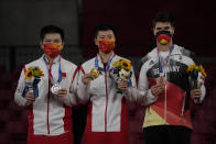 From left silver medalist Fan Zhendong of China, gold medalist Ma Long of China and bronze medalist Dimitrij Ovtcharov of Germany pose with their medals for the table tennis men's singles at the 2020 Summer Olympics, Friday, July 30, 2021, in Tokyo. (AP Photo/Kin Cheung)