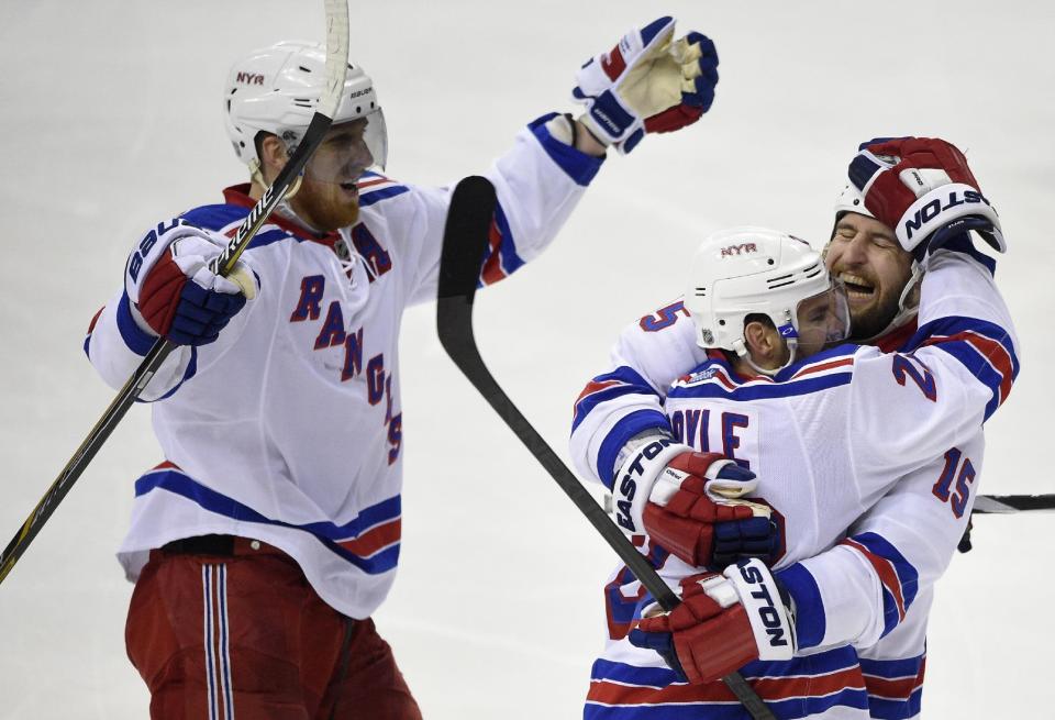 New York Rangers defenseman Dan Boyle (22) celebrates his goal with Tanner Glass (15) and Marc Staal, left, during the third period of Game 6 in the second round of the NHL Stanley Cup hockey playoffs against the Washington Capitals, Sunday, May 10, 2015, in Washington. The Rangers won 4-3. (AP Photo/Nick Wass)