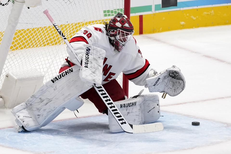 Carolina Hurricanes goaltender Alex Nedeljkovic leans forward to cover up a shot on the net during the first period of the team's NHL hockey game against the Dallas Stars in Dallas, Saturday, Feb. 13, 2021. (AP Photo/Tony Gutierrez)