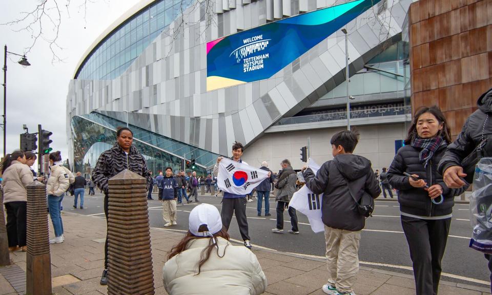 <span>A South Korean fan poses outside the <a class="link " href="https://sports.yahoo.com/soccer/teams/tottenham-hotspur/" data-i13n="sec:content-canvas;subsec:anchor_text;elm:context_link" data-ylk="slk:Tottenham Hotspur;sec:content-canvas;subsec:anchor_text;elm:context_link;itc:0">Tottenham Hotspur</a> Stadium in London.</span><span>Photograph: Elli Birch/IPS/Shutterstock</span>