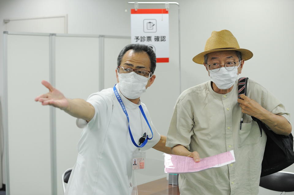 A medical worker guides a person at a coronavirus mass vaccination center, June 9, 2021 in Tokyo, Japan. / Credit: DAVID MAREUIL/Getty