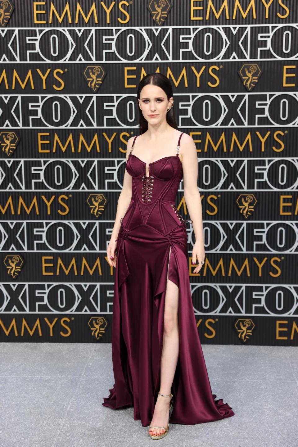 Rachel Brosnahan wears a plum gown on the Emmys red carpet.