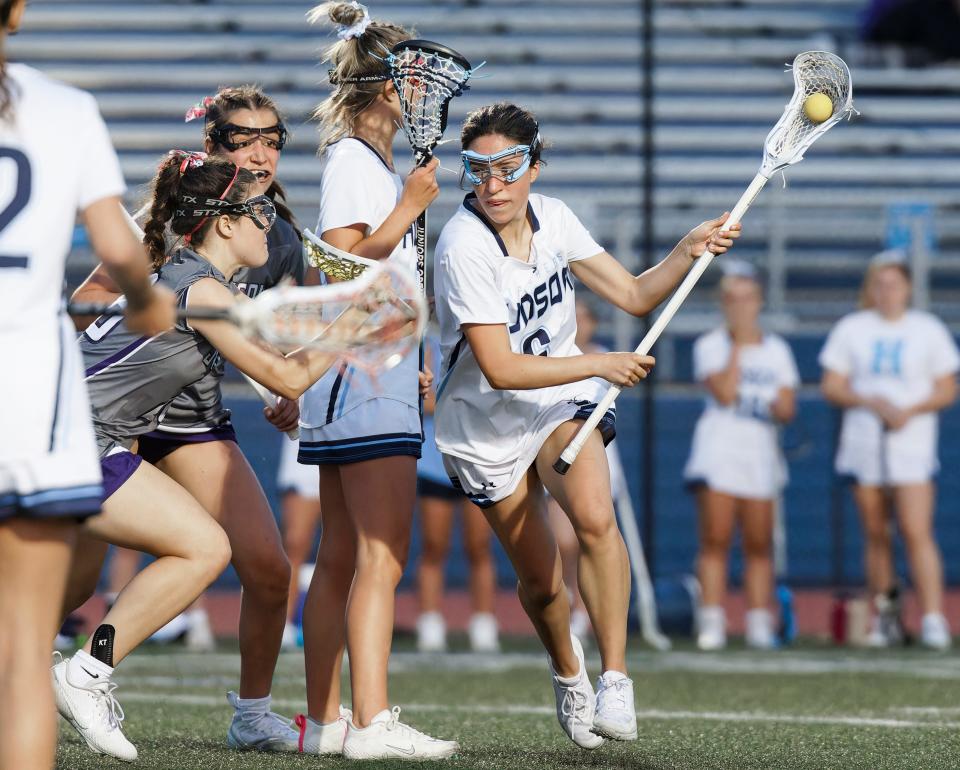 Hudson's Emma Palmer works her way around a screen set by Ryan St. Pierre against Jackson in a girls lacrosse game in Hudson in April, 2023.