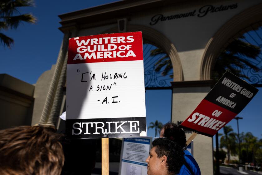 Los Angeles, CA - July 26: Someone carried a sign with the statement, "I'm Holding a Sign - A.I.," while members of the Writers Guild of America (WGA), joined by members of the Screen Actors Guild (SAG) and American Federation of Television and Radio Artists (AFTRA), come together to picket in front of Paramount Studios, in Los Angeles, CA, Wednesday, July 26, 2023. Entertainment's largest guilds have come together, during disputed contract negotiations with the Alliance of Motion Picture and Television Producers (AMPTP).(Jay L. Clendenin / Los Angeles Times)