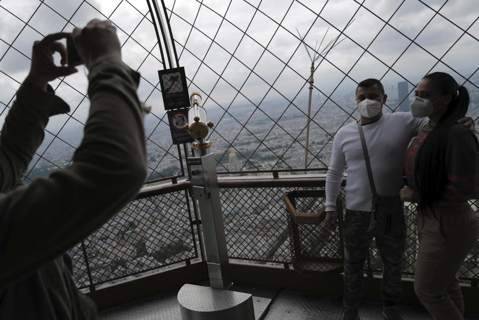 Visitors take photo with their phone from the third level during the opening up of the top floor of the Eiffel Tower, Wednesday, July 15, 2020 in Paris. The top floor of Paris' Eiffel Tower reopened today as the 19th century iron monument re-opened its first two floors on June 26 following its longest closure since World War II. (AP Photo/Francois Mori)