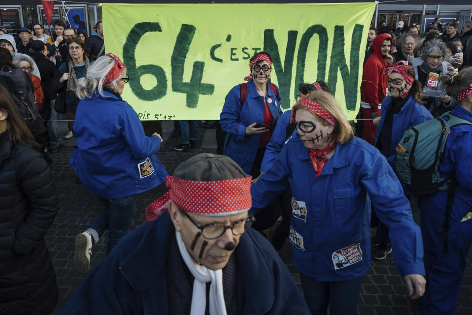 Protesters dance during a protest in Paris, Saturday, March 18, 2023. A spattering of protests were planned to continue in France over the weekend against President Macron's controversial pension reform, as garbage continued to reek in the streets of Paris and beyond owing to continuing action by refuse collectors. (AP Photo/Lewis Joly)