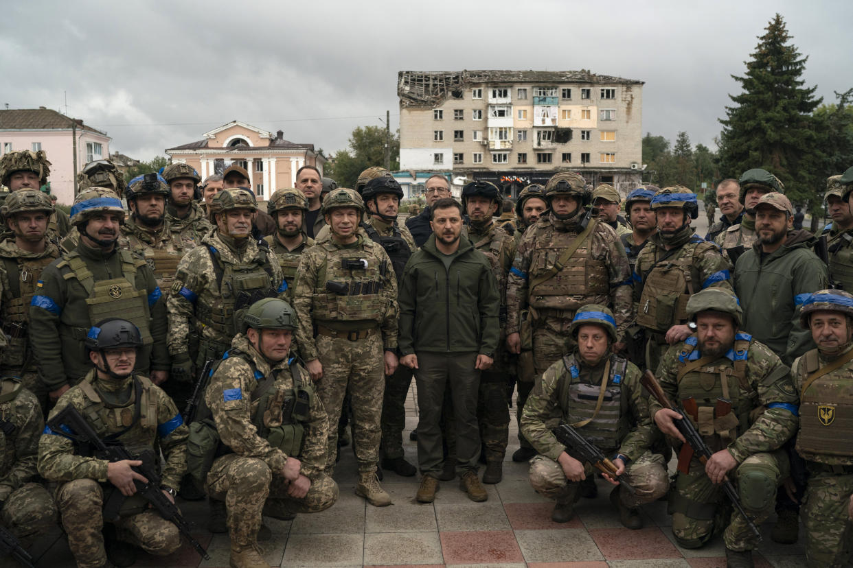 Ukrainian President Volodymyr Zelenskyy poses for a photo with soldiers after attending a national flag-raising ceremony in the freed Izium, Ukraine, Wednesday, Sept. 14, 2022. Zelenskyy visited the recently liberated city on Wednesday, greeting soldiers and thanking them for their efforts in retaking the area, as the Ukrainian flag was raised in front of the burned-out city hall building. (AP Photo/Leo Correa)