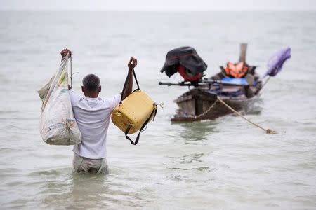 Hong Klathalay walks towards his fishing boat in Khao Lak, Phang Nga province December 14, 2014. REUTERS/Damir Sagolj