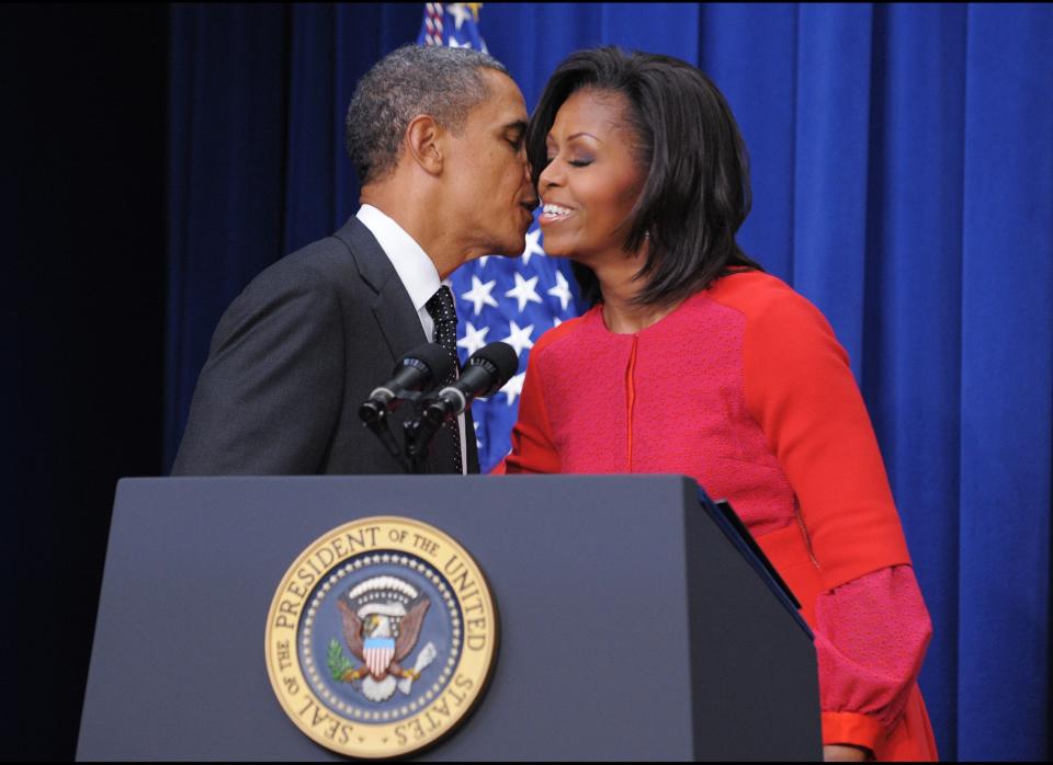 First Lady Michelle Obama kisses US President Barack Obama after introducing him during a signing ceremony for a bill which provides tax credits to companies to put veterans back to work November 21, 2011 in the South Court Auditorium, next to the White House in Washington, DC. AFP PHOTO/Mandel NGAN (Photo credit should read MANDEL NGAN/AFP/Getty Images)