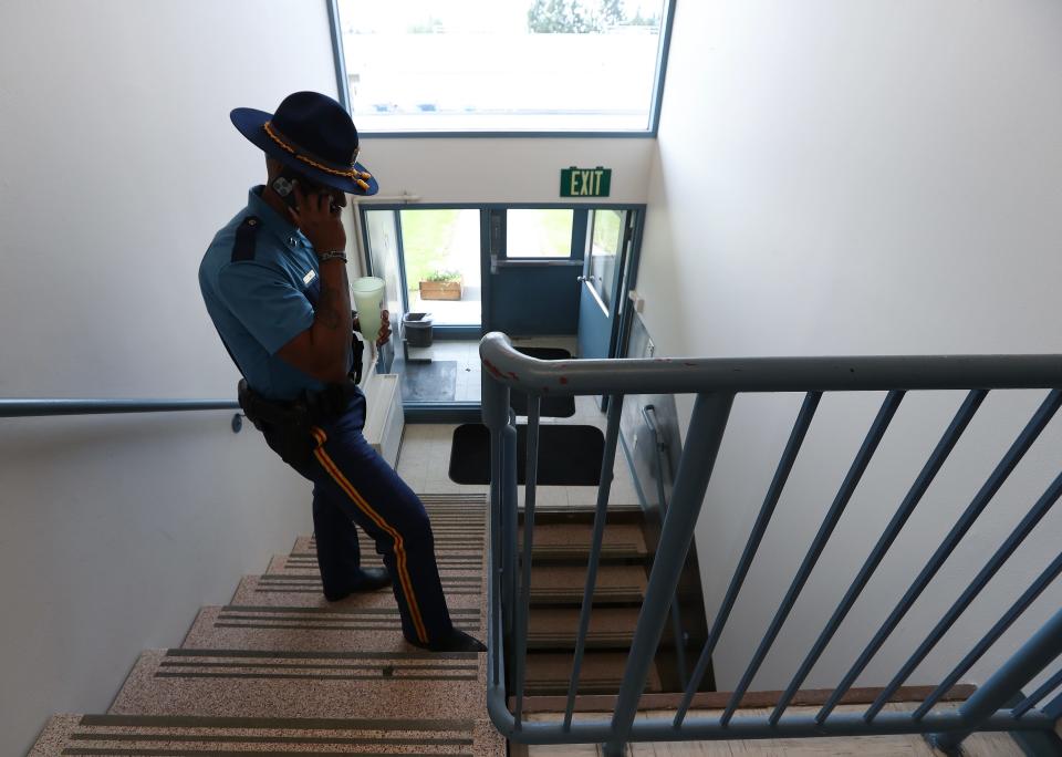 Capt. Cornelius "Moose" Sims, of the Alaska State Troopers, takes a call from a trooper on the K-9 team in a stairwell outside his office in Anchorage, Alaska, on Aug. 23, 2023.