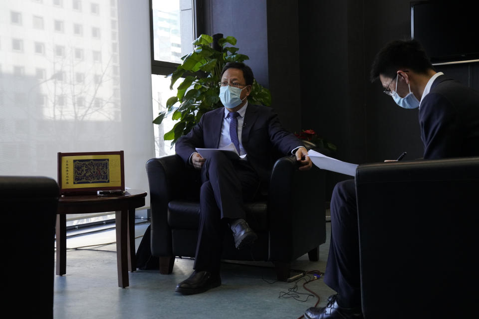 Xu Guixiang, left, the deputy director-general of the Xinjiang Communist Party publicity department, speaks during an interview in Beijing on Monday, Dec. 21, 2020. The Chinese Communist Party official signaled Monday that there would likely be no let-up in its crackdown in the Xinjiang region, but said the government's focus is shifting more to addressing the roots of extremism. (AP Photo/Ng Han Guan)