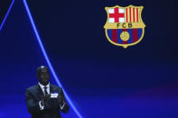 Ivorian coach and former player Yaya Toure shows the name of Barcelona during the soccer Champions League draw in Istanbul, Turkey, Thursday, Aug. 25, 2022. (AP Photo/Emrah Gurel)