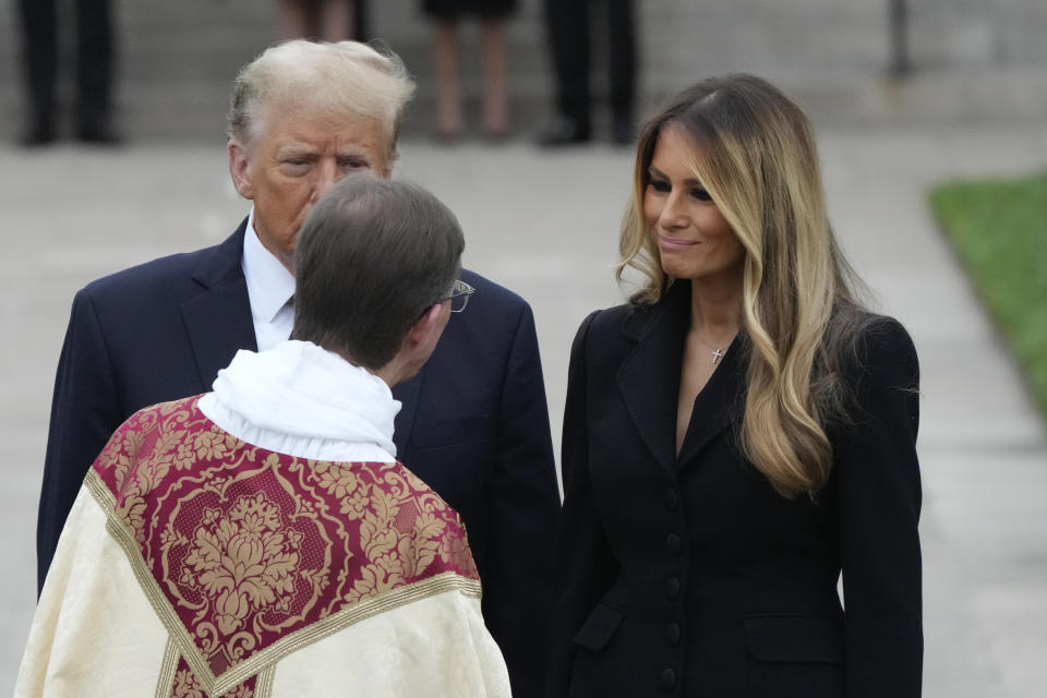 Former first lady Melania Trump, right, talks with a priest as former President Donald Trump looks on, after the funeral for the former first lady's mother, Amalija Knavs, Thursday, Jan. 18, 2024, at the Church of Bethesda-by-the-Sea in Palm Beach, Fla. (AP Photo/Rebecca Blackwell)