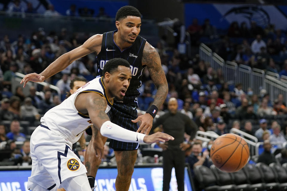 Denver Nuggets guard Monte Morris, left, goes after a loose ball in front of Orlando Magic guard Gary Harris during the second half of an NBA basketball game, Wednesday, Dec. 1, 2021, in Orlando, Fla. (AP Photo/John Raoux)