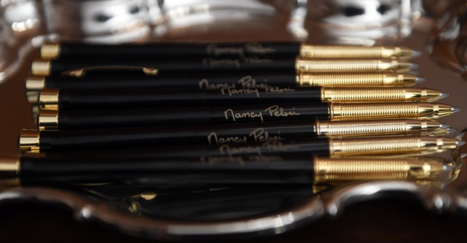 Each pen was emblazoned with Pelosi's name printed in gold. Source: Associated Press