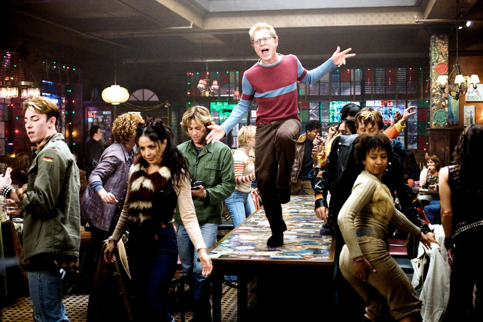 anthony rapp as mark on a table among the cast singing la vie boheme in rent