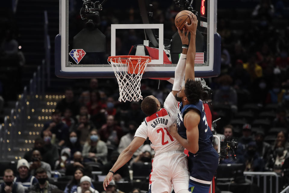 Minnesota Timberwolves' Karl-Anthony Towns, right, is fouled by Washington Wizards' Daniel Gafford during the first half of an NBA basketball game Wednesday, Dec. 1, 2021, in Washington. (AP Photo/Luis M. Alvarez)