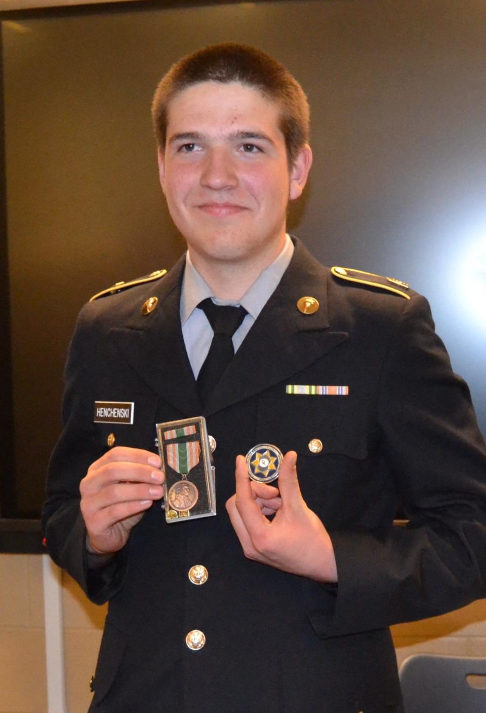 Gage Hencheski, a first sergeant in the JROTC program at Poudre High School in Fort Collins, Colo., shows off the Meritorious Commendation Ribbon and challenge coin he received during a ceremony Wednesday honoring him for his efforts to help a man pinned overnight underneath his crashed truck.