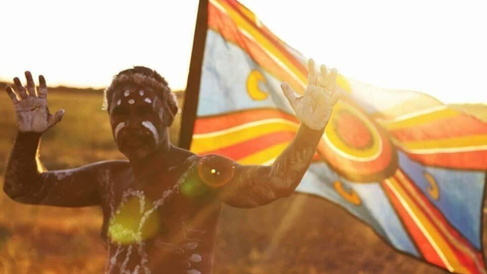 Kamilaroi man Alfred Priestley painted up with a flag. 