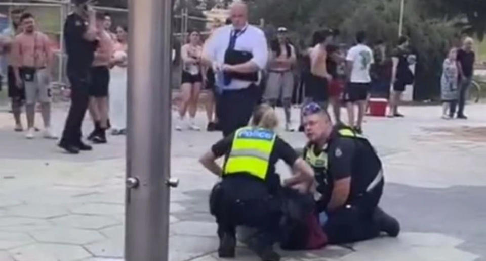 Police attending to 18-year-old male who was stabbed at St Kilda beach in Melbourne. 