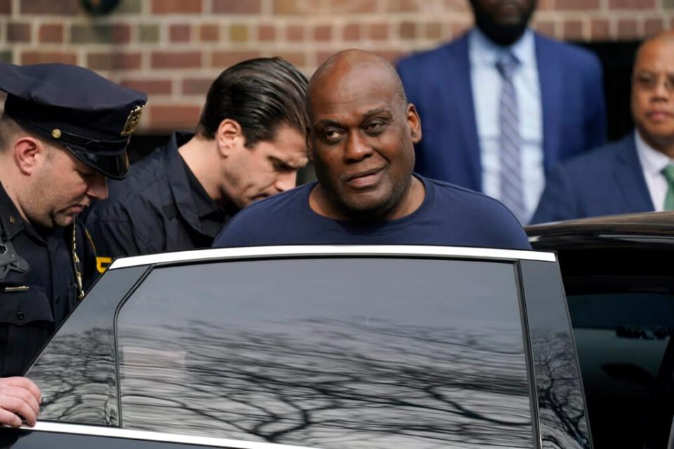 Law enforcement officials lead subway shooting suspect Frank R. James, 62, center right, away from a police station and into a vehicle, in New York, Wednesday, April 13, 2022. James, accused of shooting 10 people on a Brooklyn subway train, was arrested Wednesday and charged with a federal terrorism offense. (AP Photo/John Minchillo)